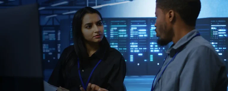 Staff talking in front of computer screens